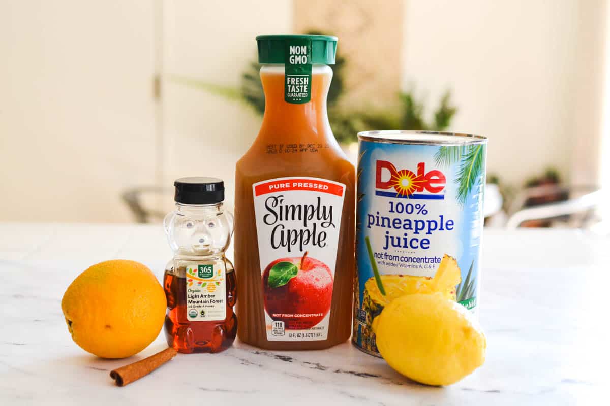 Ingredients to make hot spiced apple cider on a counter.