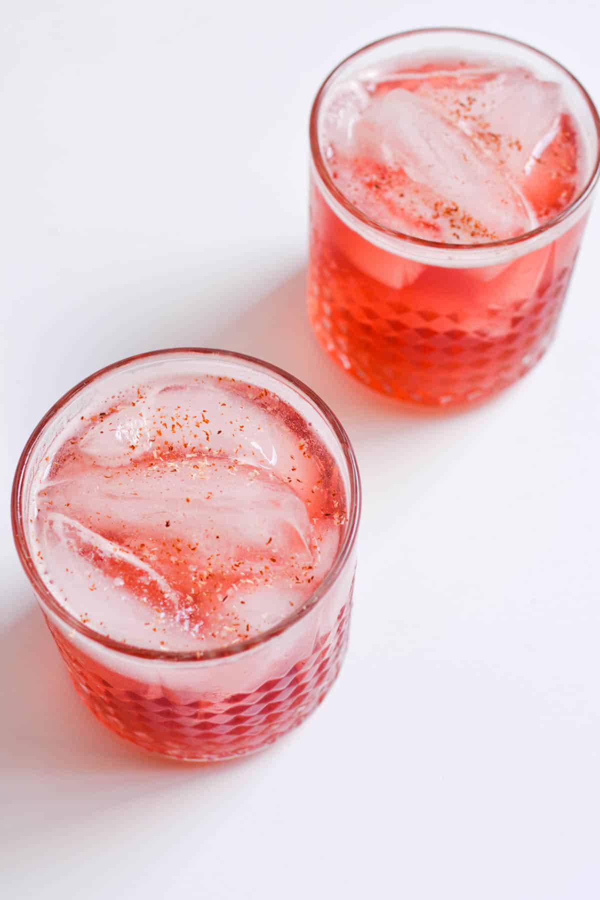 2 cocktail glasses with a cranberry drink in them.