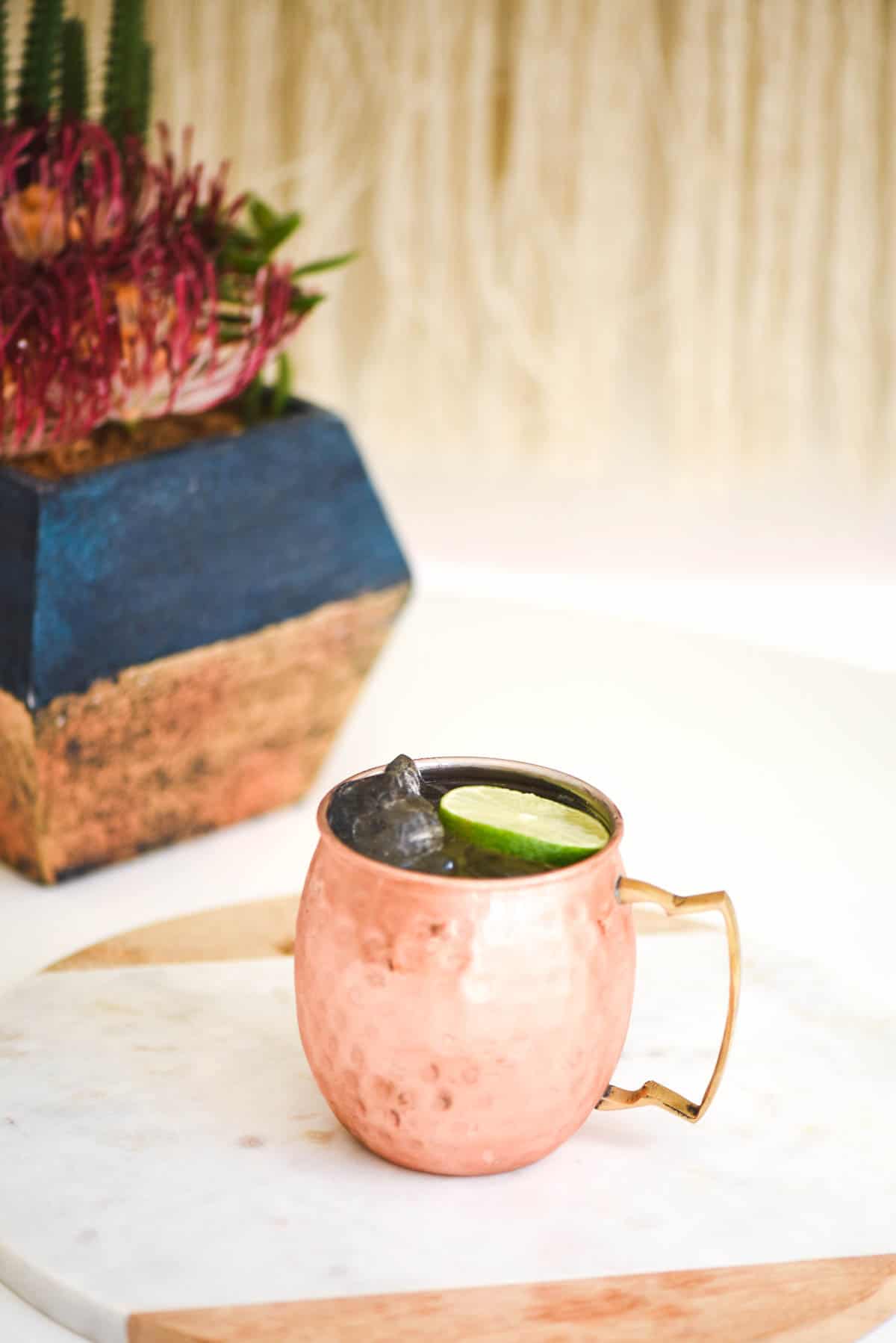 A copper mug with a cocktail on a table.