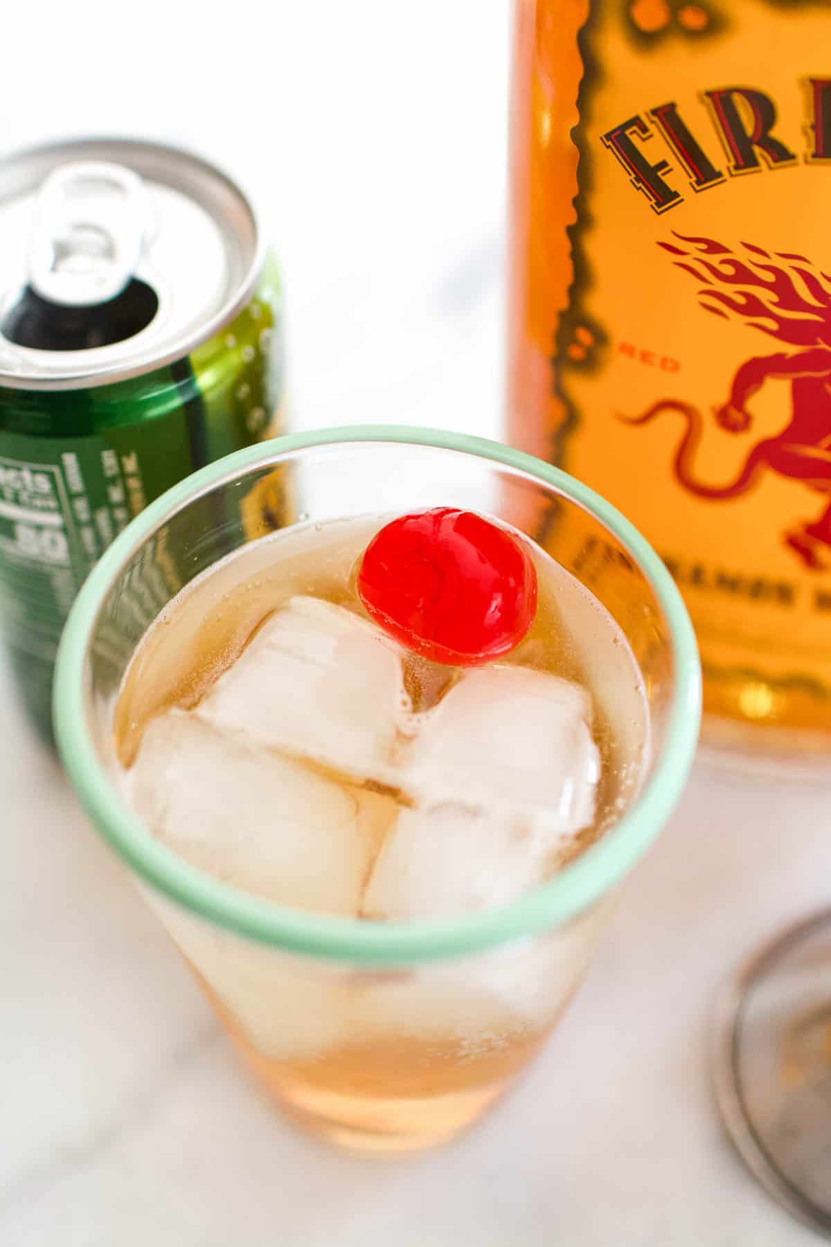 Close up of an overhead view of a cocktail topped with a cherry.
