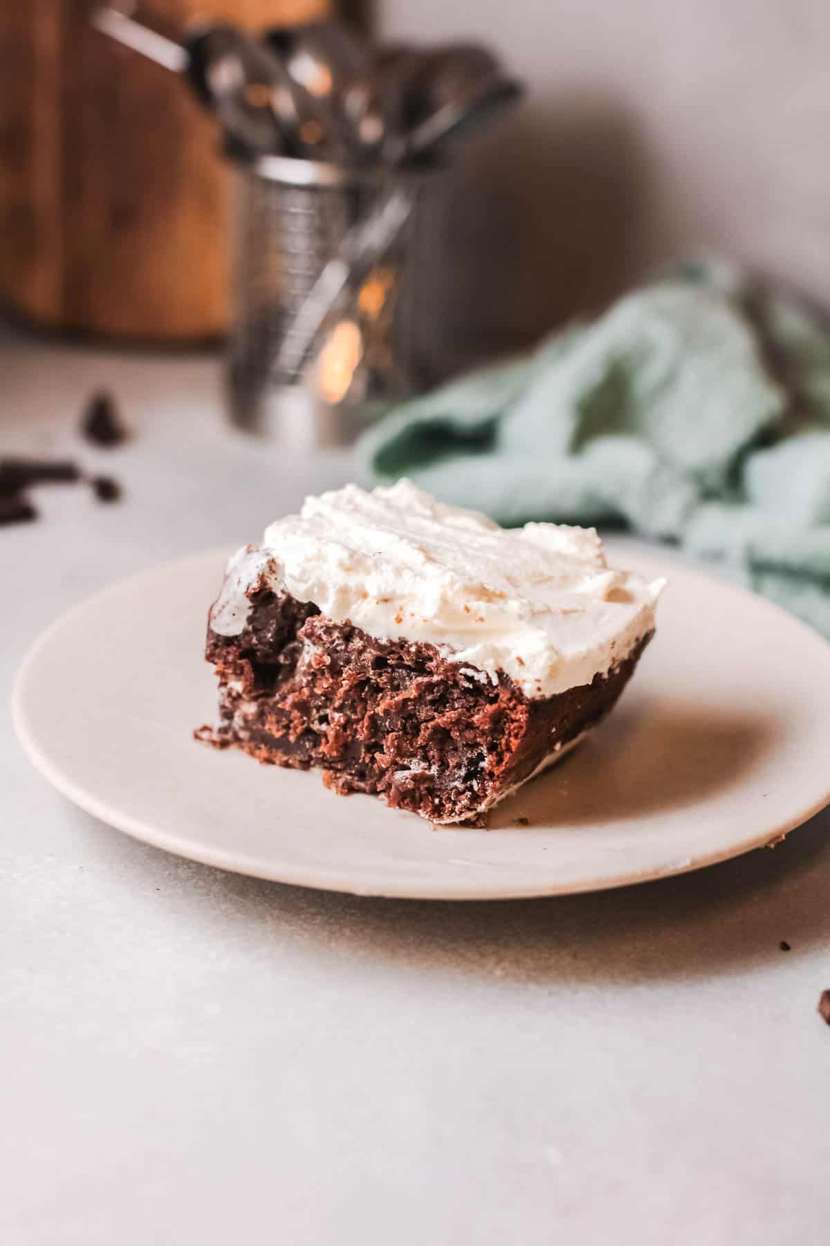 A piece of chocolate cake on a plate topped with white frosting.