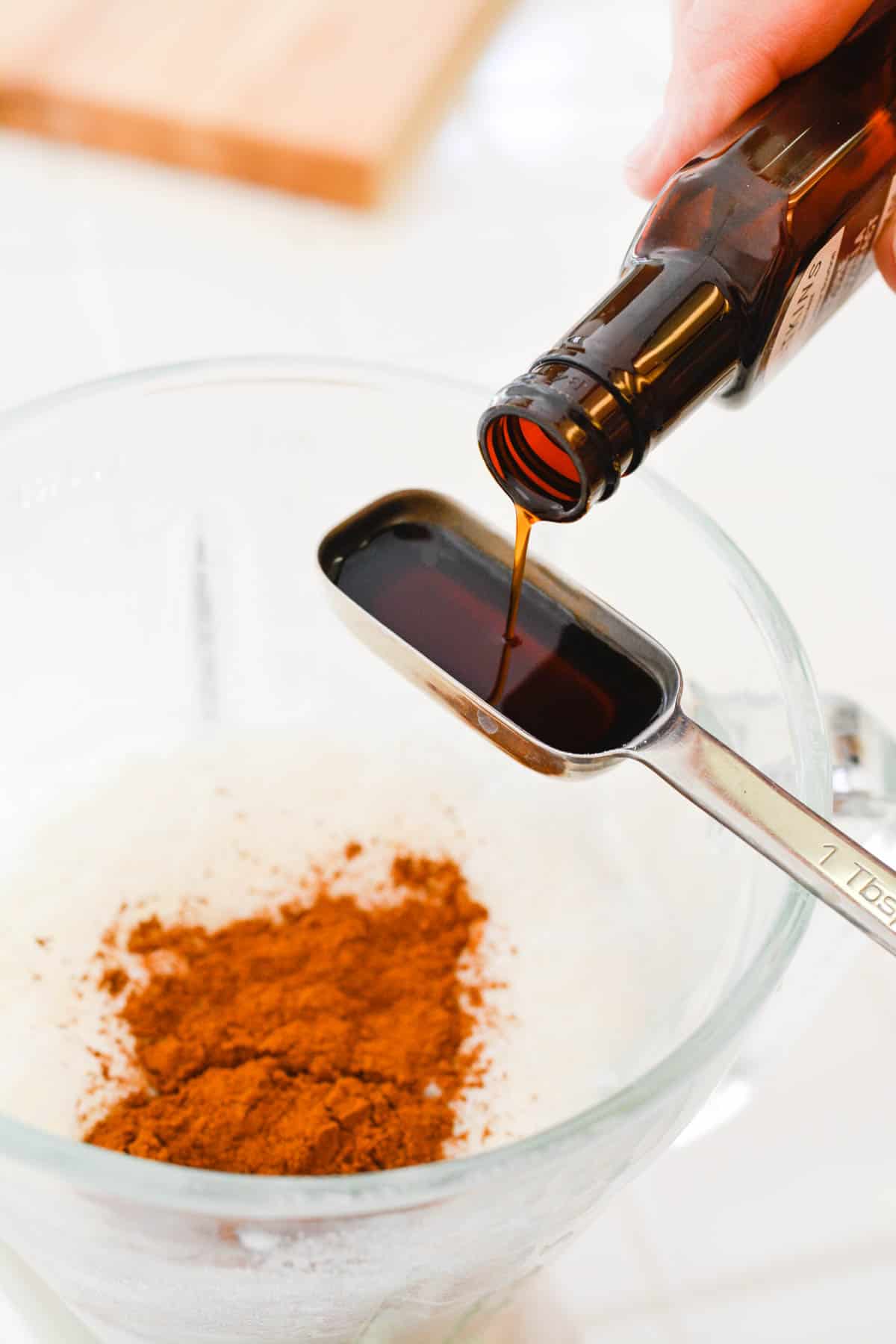 Close up of vanilla being poured into a measuring spoon.
