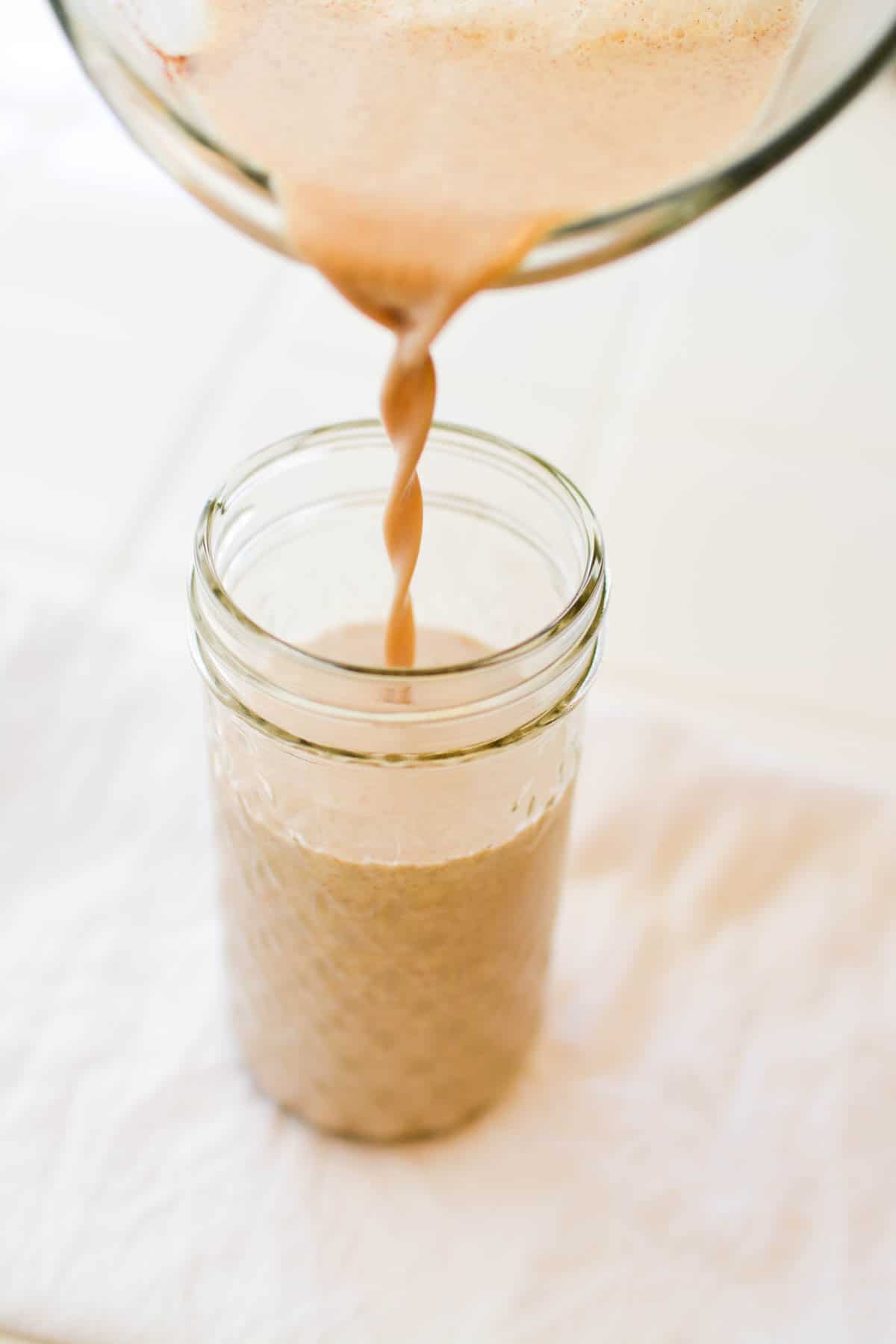 Close up of coffee creamer being poured into a jar.