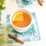 Close up of an overhead shot of hot apple cider in a small white cup.