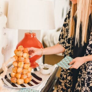 Close up of woman taking a donut hole from a donut tower.