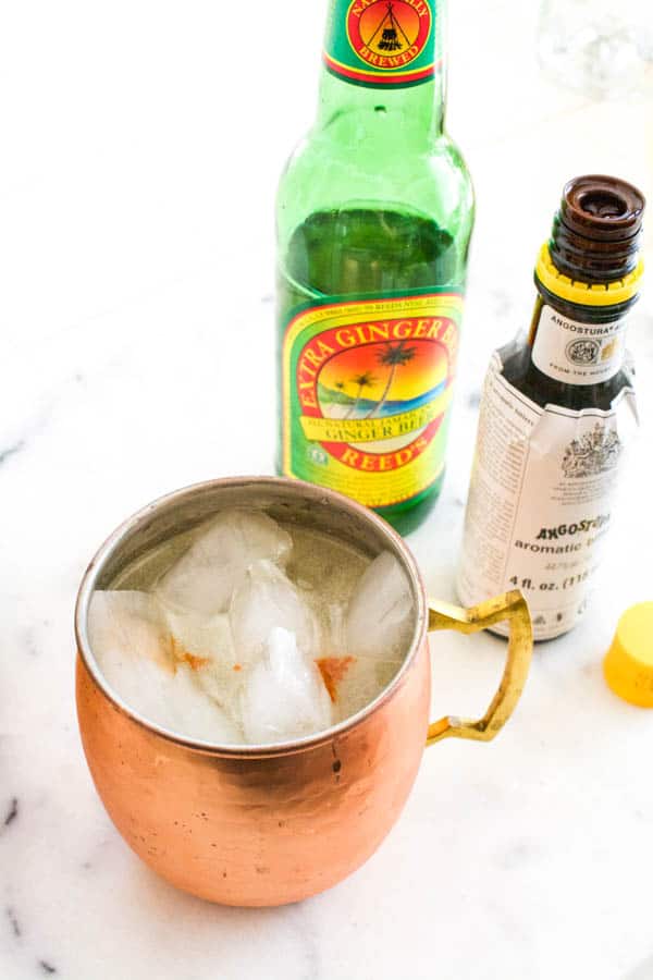 Overhead view of a copper mule mug next to bitter and ginger beer.