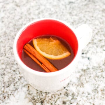 Close up of a mug with Mulled Cider with cranberry and apple juices.