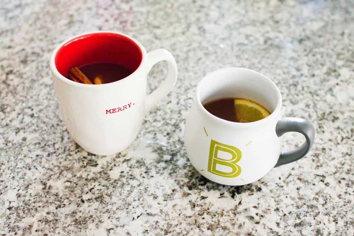 2 mugs holding Christmas cranberry punch on a counter.