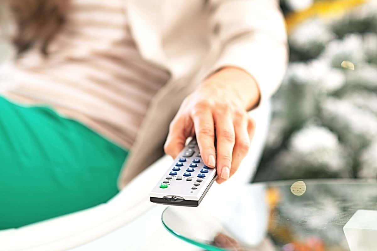 Close up of a woman's hand holding a remote control.