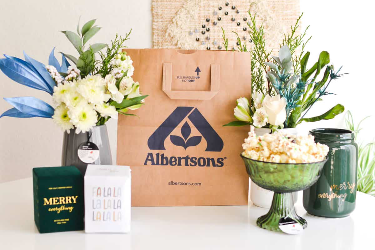 Albertsons bag next to some floral arrangements and gift ideas that can be found in the floral department.