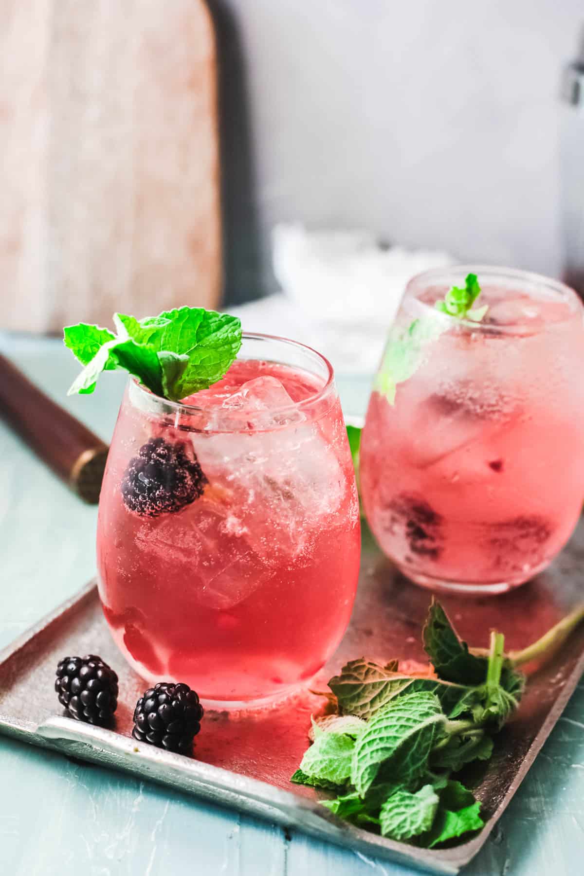 Stemless wine glasses on a tray with a pink cocktail in it.