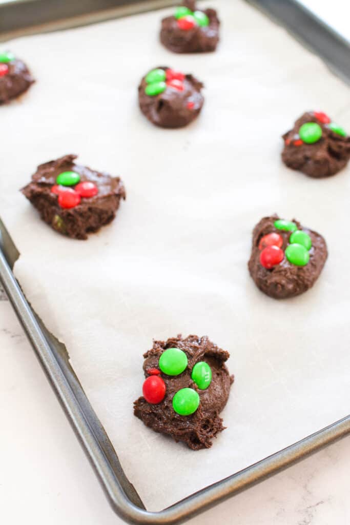 Chocolate M&M cookie batter on a baking sheet.