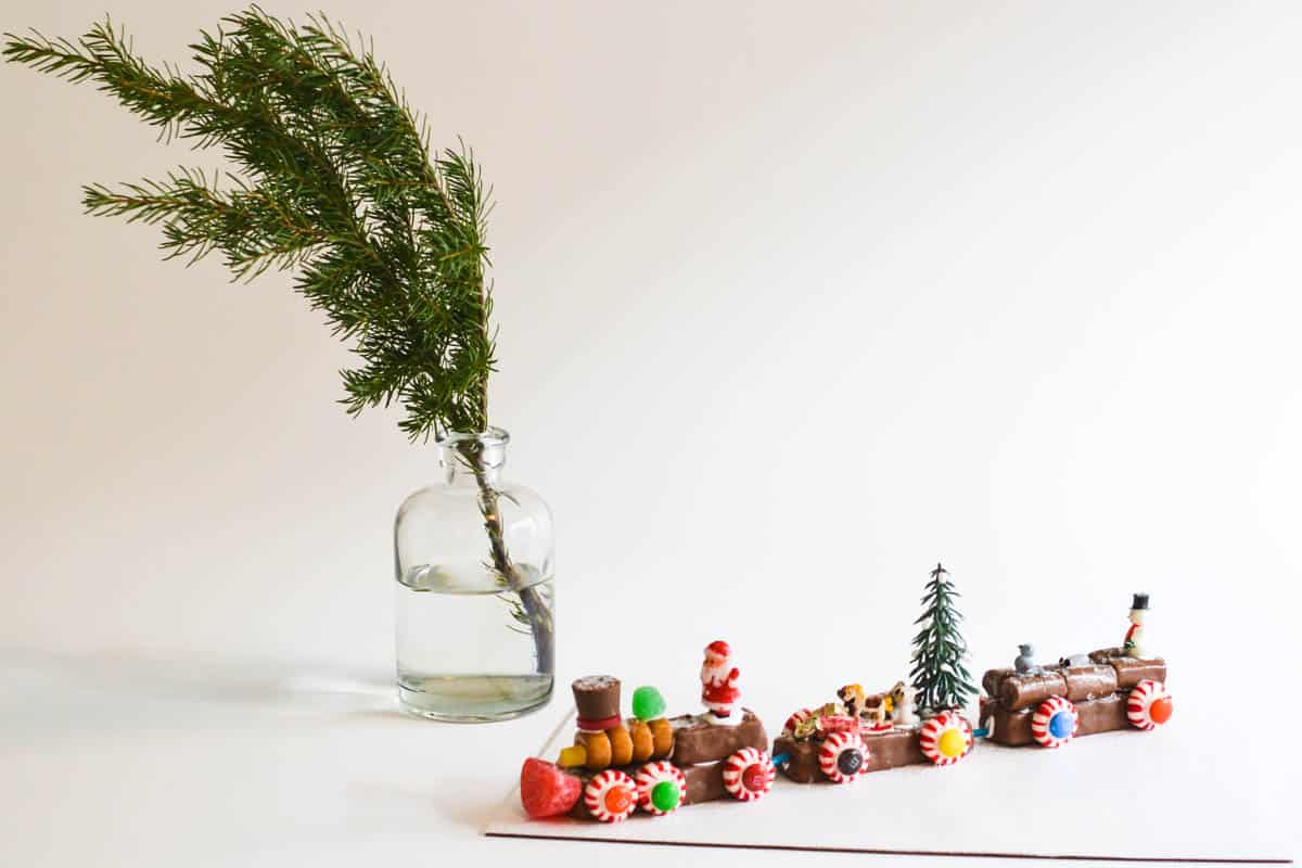 A candy train for Christmas on a cake board on a table. 