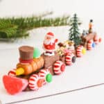 Close up of a christmas train made from candy with a small plastic Santa on top.