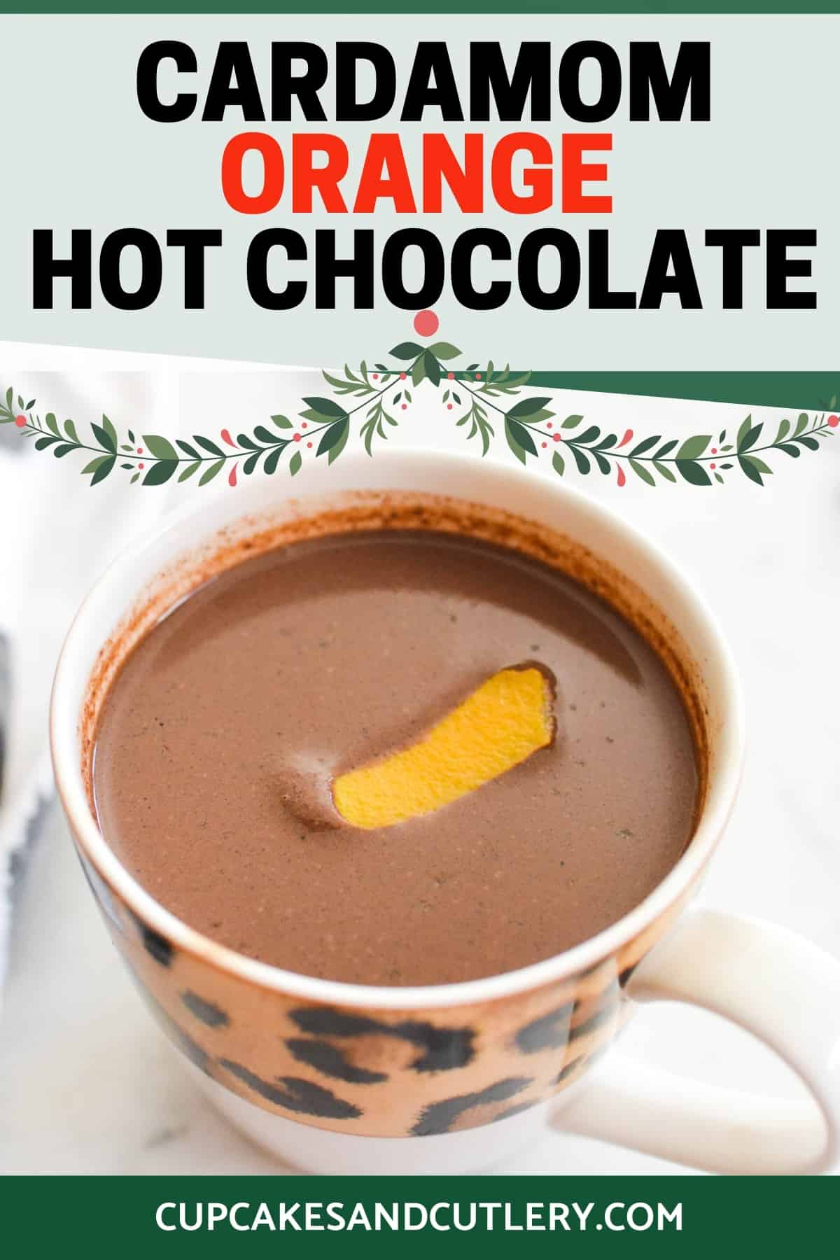 Close up of a cup of hot chocolate with a piece of orange peel on top with text around it.