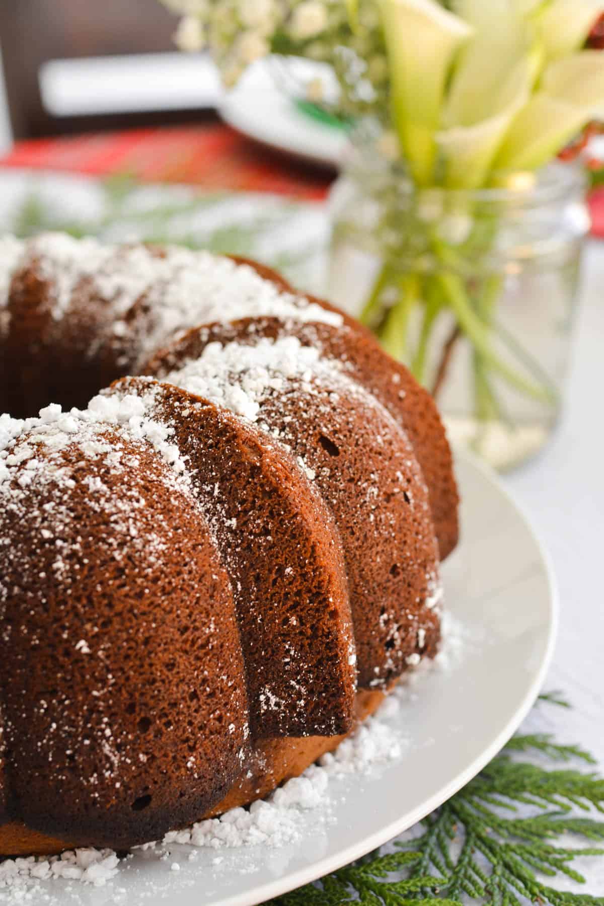 Close up of the side of a bundt cake with powdered sugar on it.