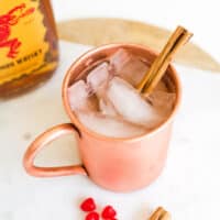 Close up of a cocktail in a copper mug on a table.