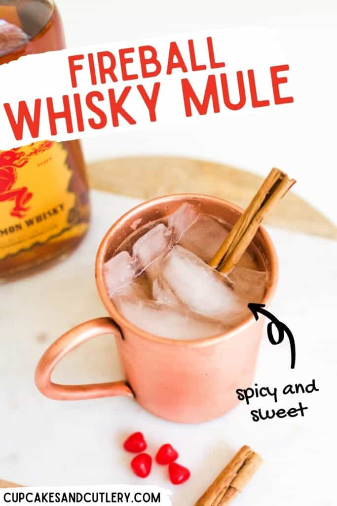 A copper mug on a table with a cinnamon whisky mule next to a bottle of Fireball.