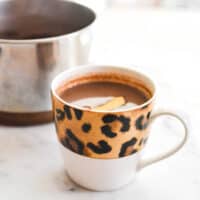 Close up of a leopard print mug holding hot chocolate.