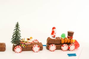 Train cars made out of candy bars and other candy with holiday miniatures on them.