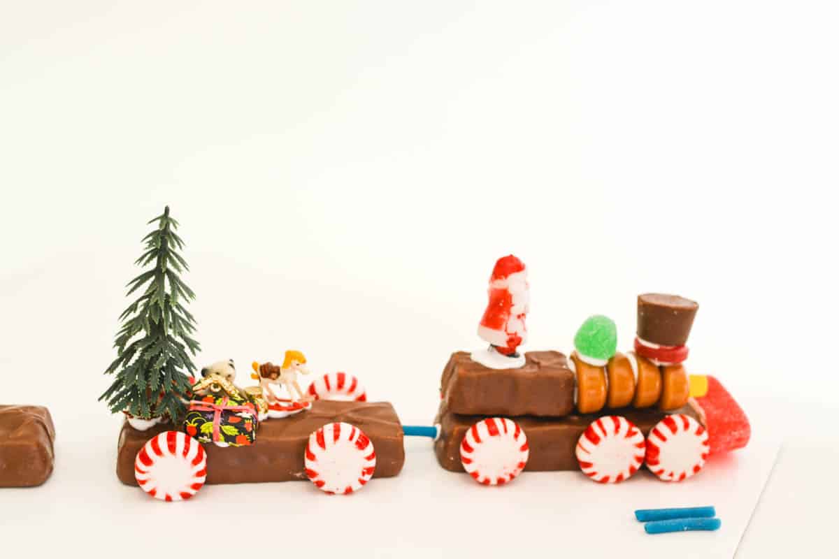 Train cars made out of candy bars and other candy with holiday miniatures on them.