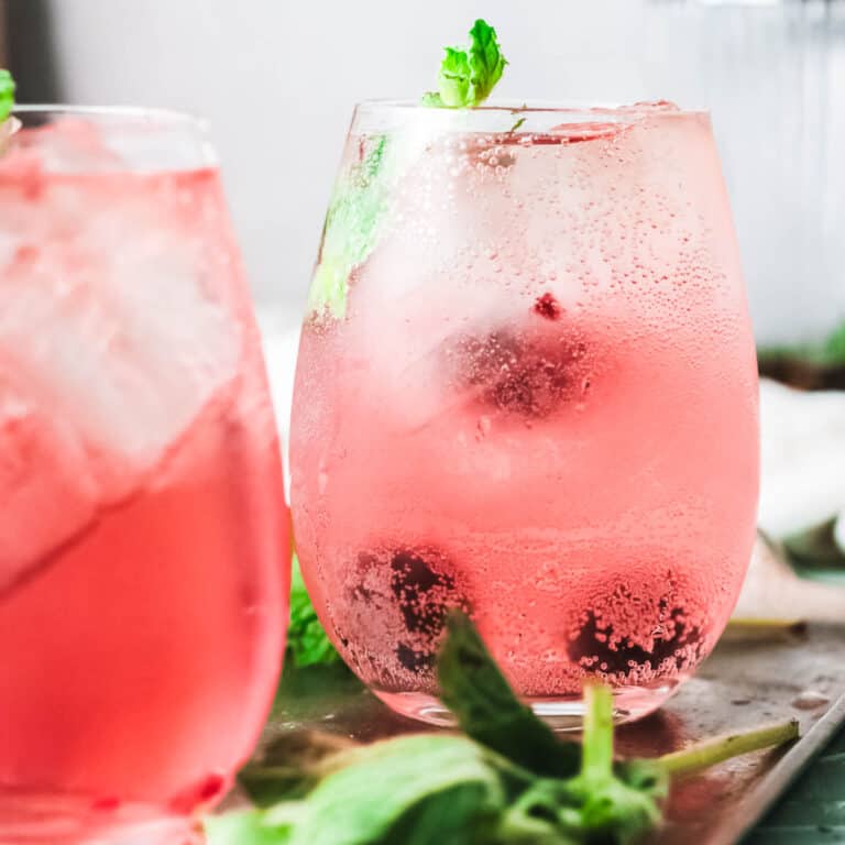 Close up of pink cocktails in stemless wine glasses.