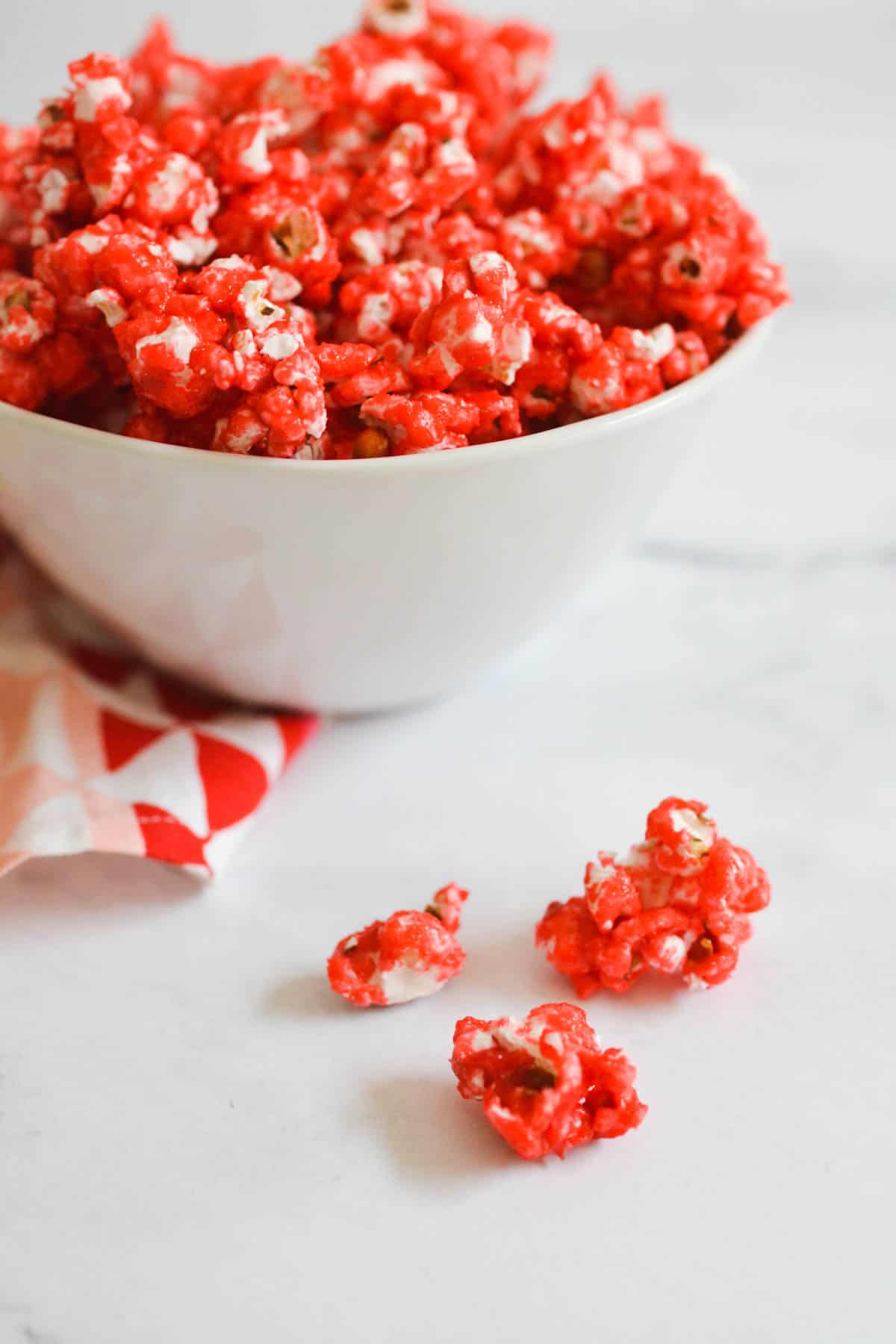 Close up of Jello popcorn on a counter in front of a bowl full of popcorn.