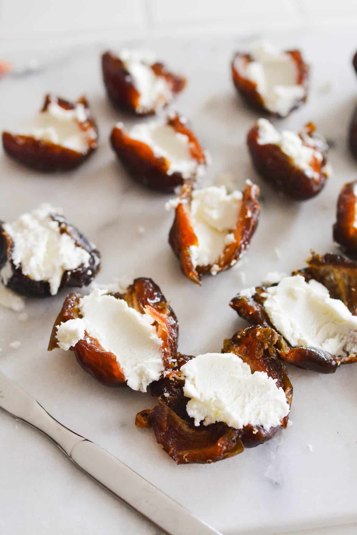 Dates stuffed with goat cheese on a cutting board.