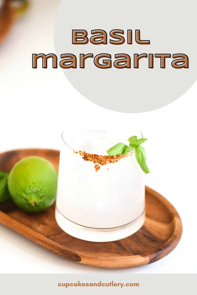 A cocktail glass on a wooden tray on a table with text near it.