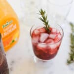 Close up of a blackberry whiskey lemonade cocktail in a glass.