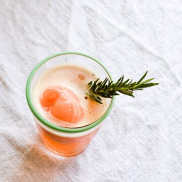 Close up of a boozy cocktail with a rosemary sprig
