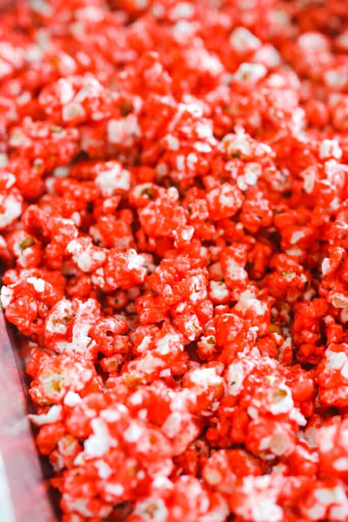 Close up of pink candy coated popcorn in a baking dish.