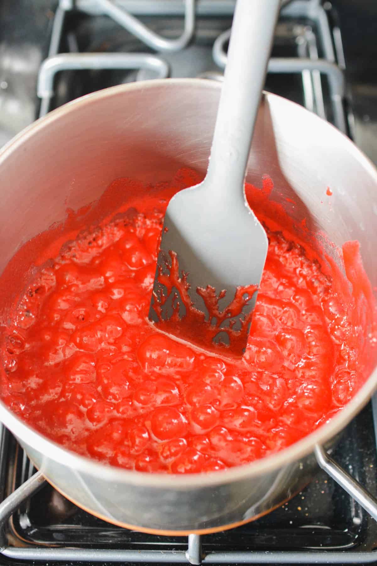 A pink candy mixture melted in a sauce pan.