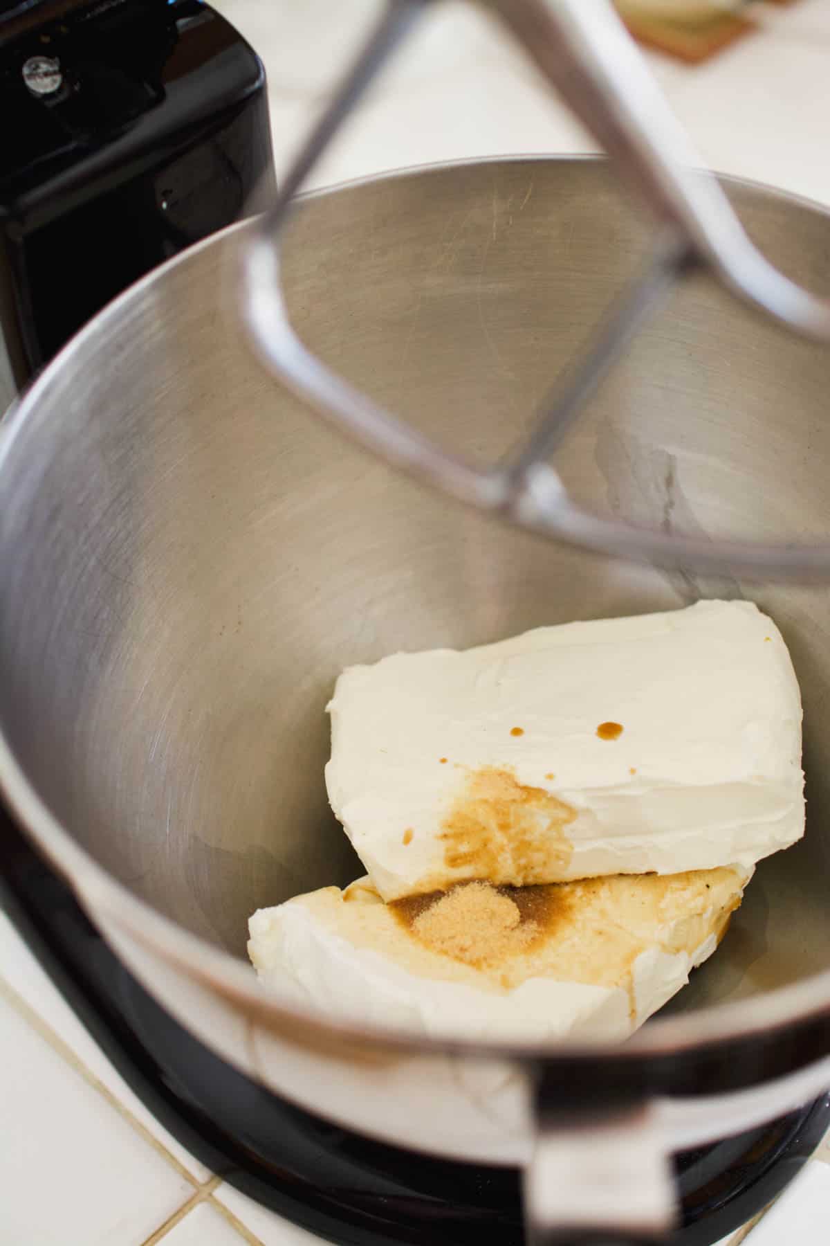 Stand mixer bowl with cream cheese and seasonsing.