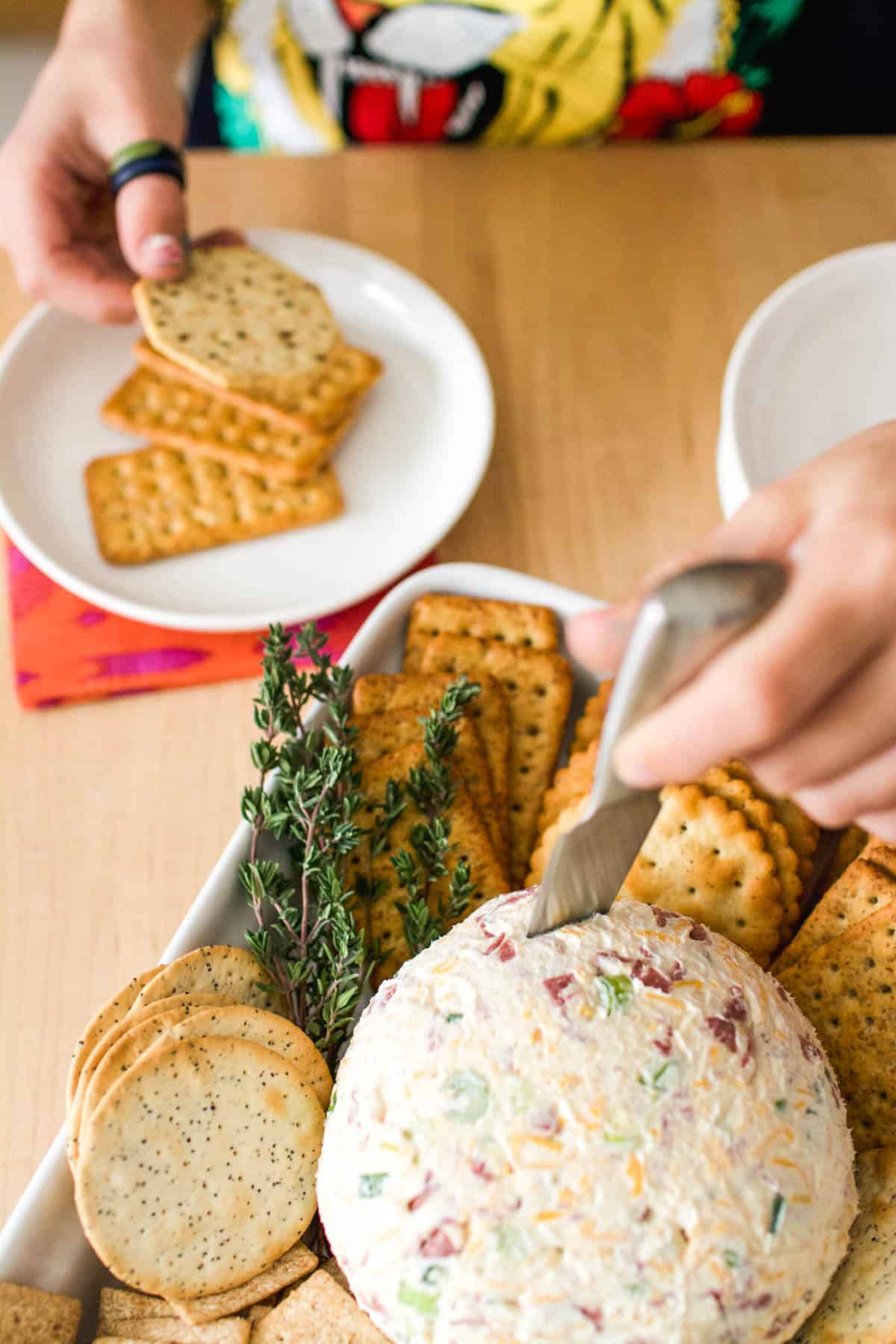 Kid using a cheese knife to serve himself some of the cheese ball appetizer.