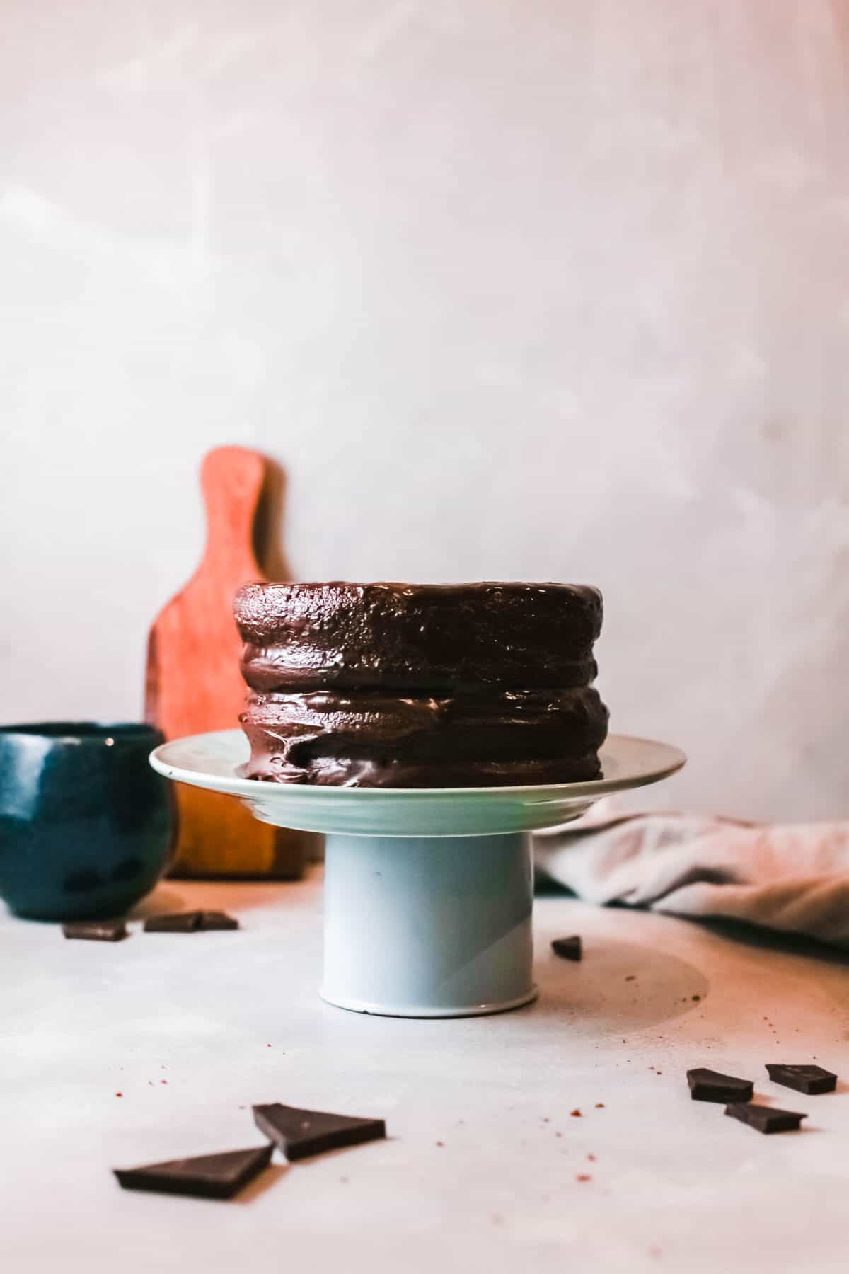 Layered Chocolate Truffle Cake on a cake plate on a counter. 