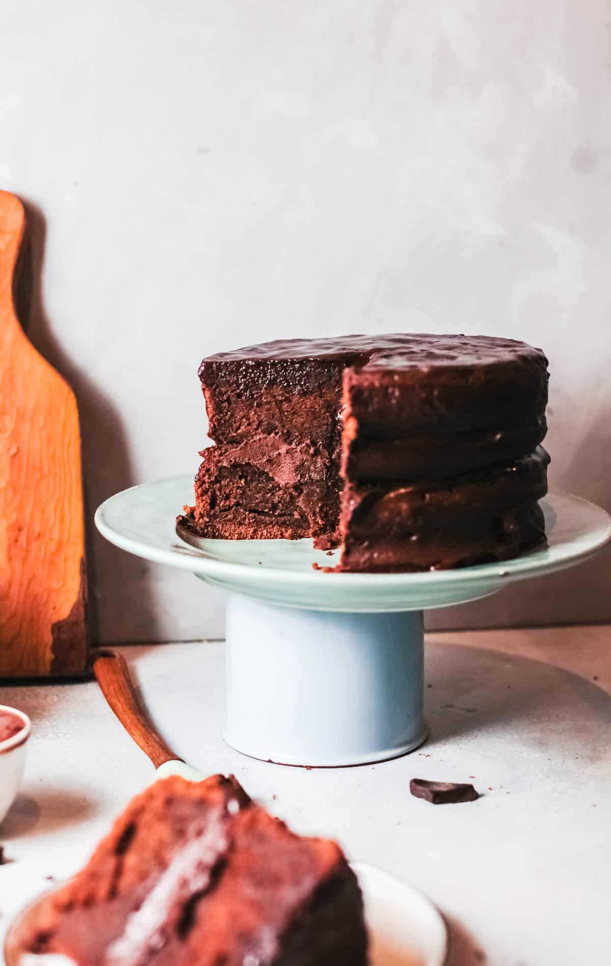 Layered Chocolate Truffle Cake on a stand on a counter. 