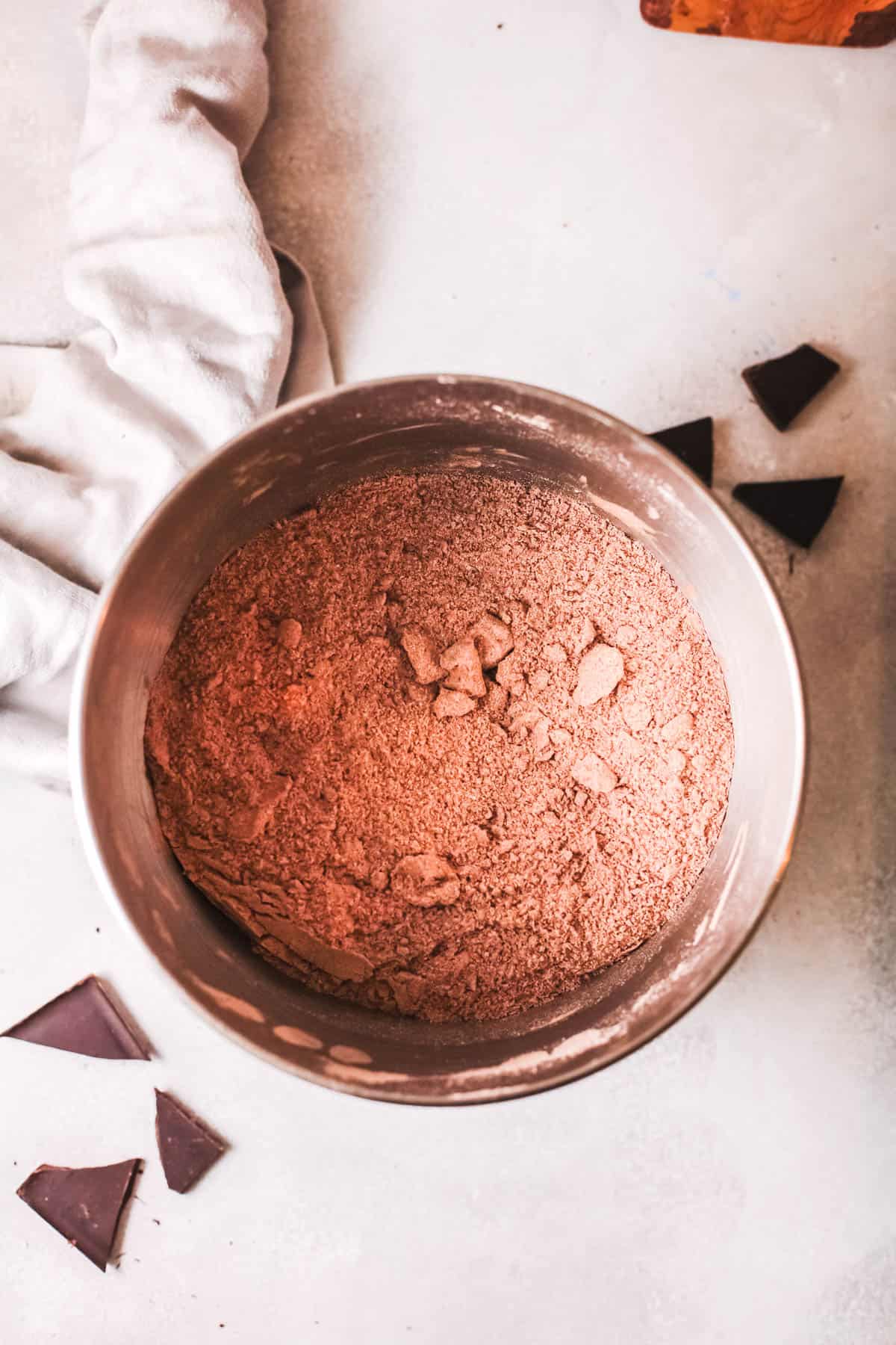 A bowl on a counter with chocolate boxed cake mix in it. 
