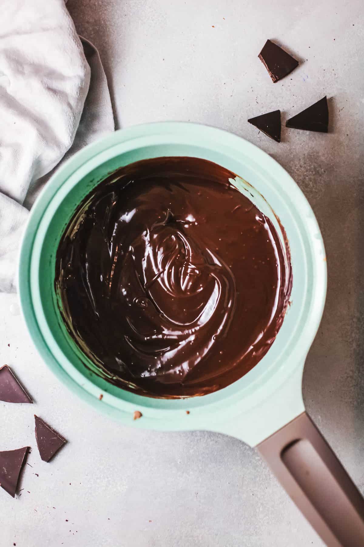 A simple chocolate ganache in a small mint colored sauce pan. 