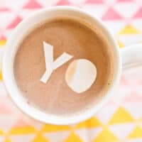 Close up of edible confetti that says "yo" in some hot cocoa.