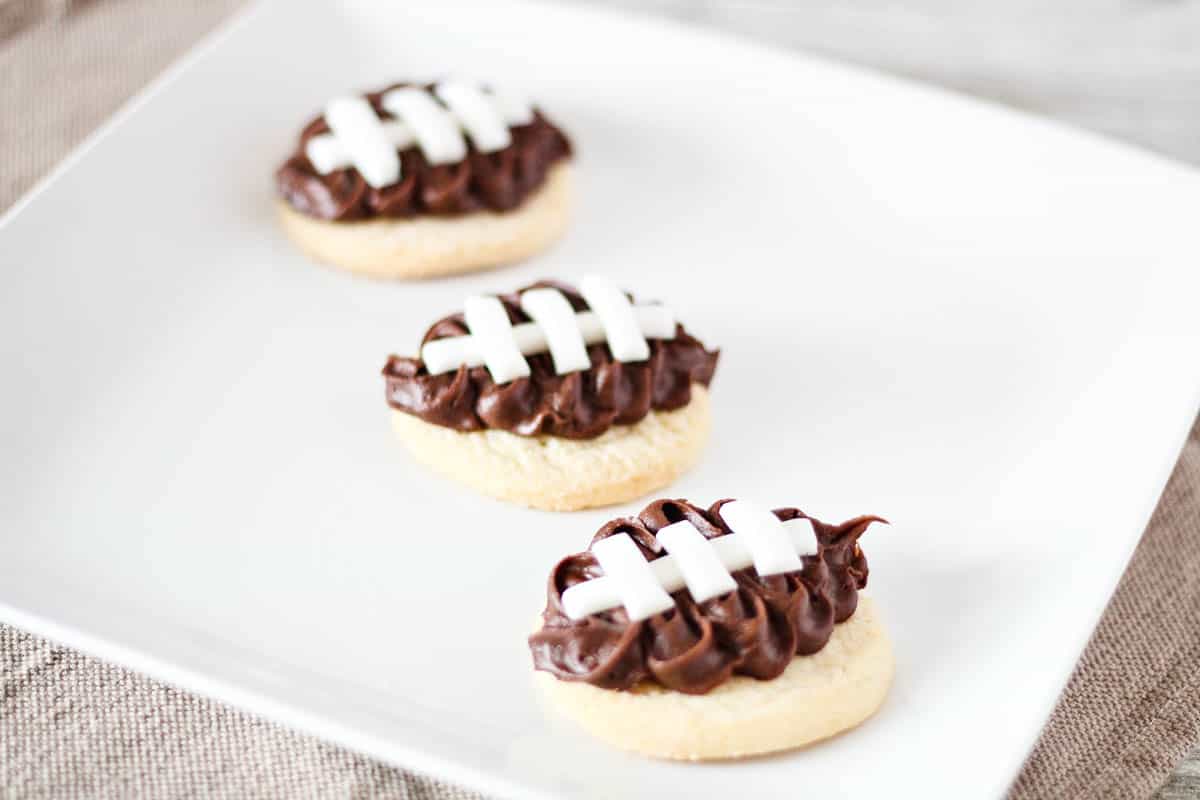 Football cookies on a plate for a tailgate dessert.