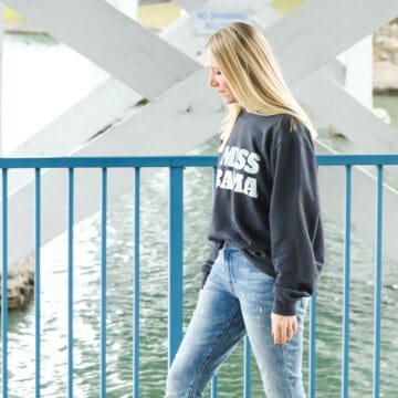 Woman wearing a graphic sweatshirt with jeans.