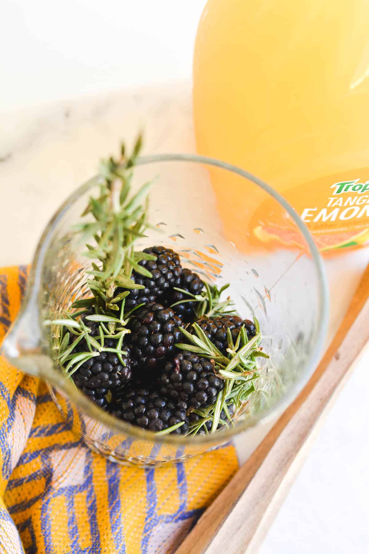 Overhead photo of a bar pitcher with fresh blackberries and rosemary.