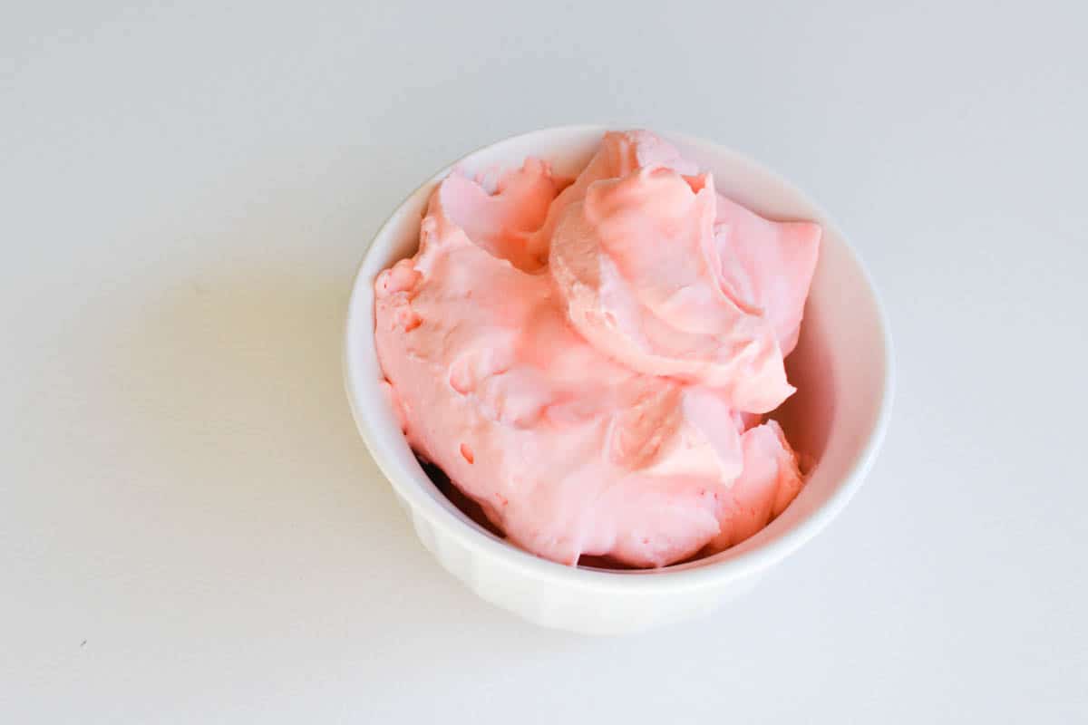 A small bowl of flavored whipped cream made with cherry Fun Dip.