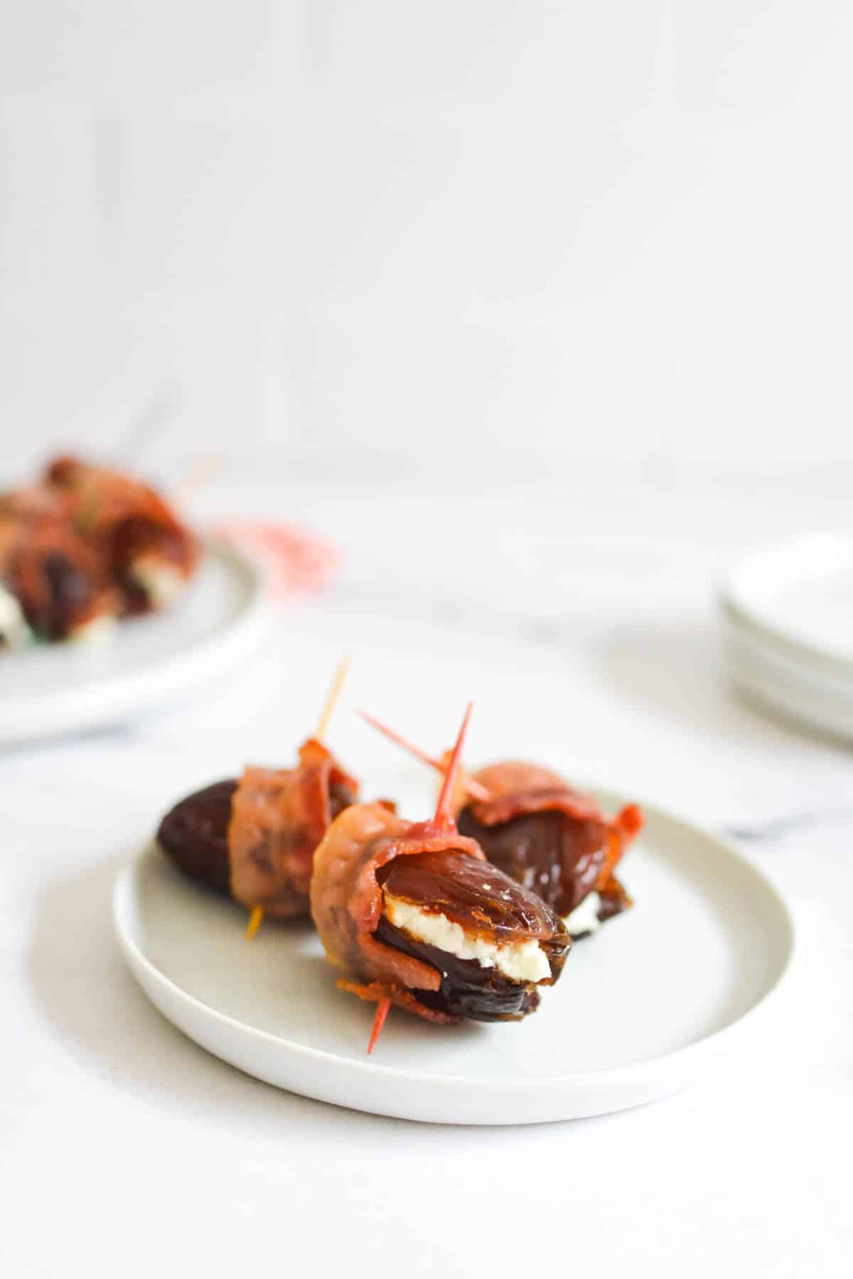 An appetizer plate with Bacon Wrapped Dates filled with goat cheese