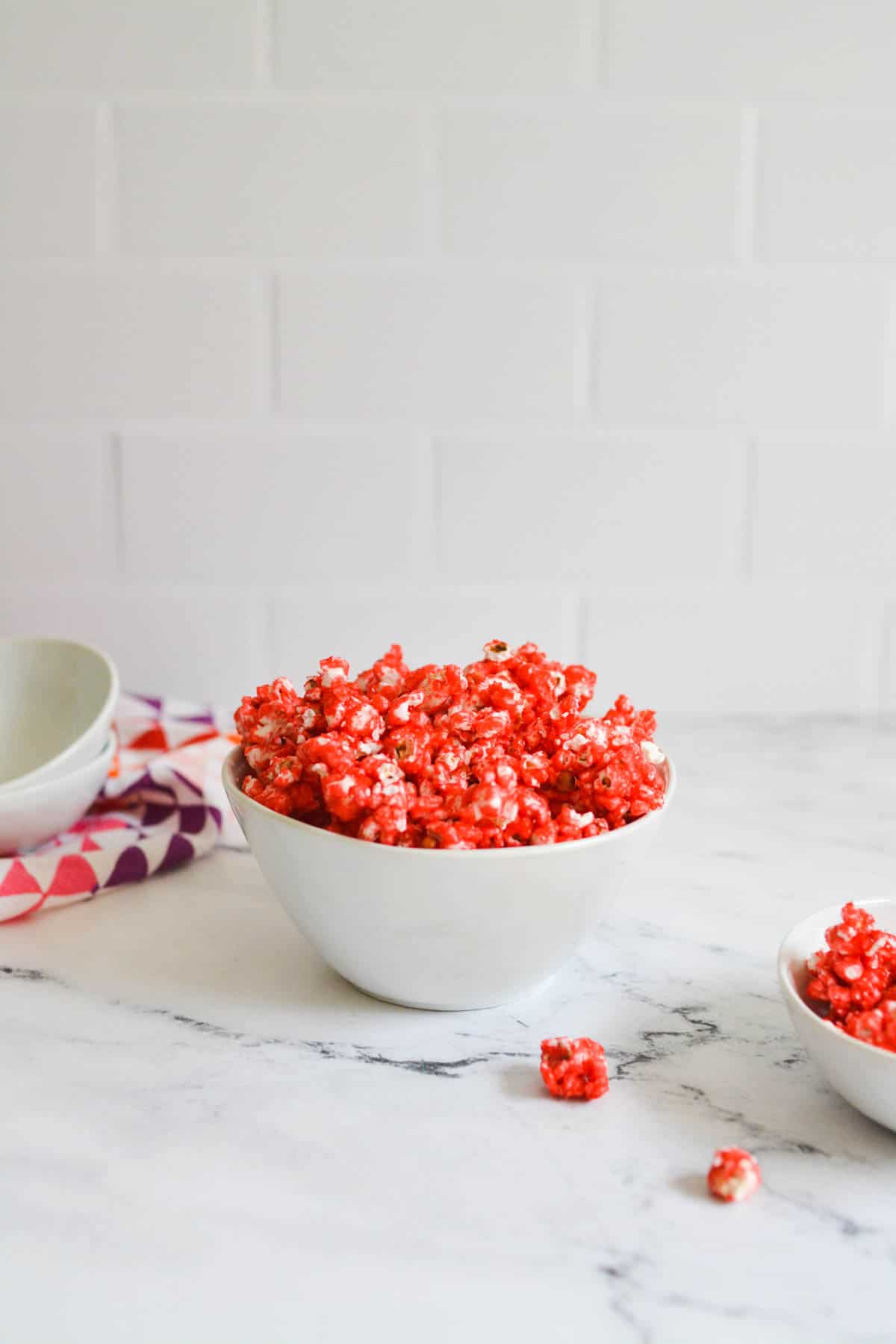 A bowl holding Cherry flavored popcorn on a counter.