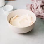 white bowl of fluffy Russian buttercream frosting sitting on the counter