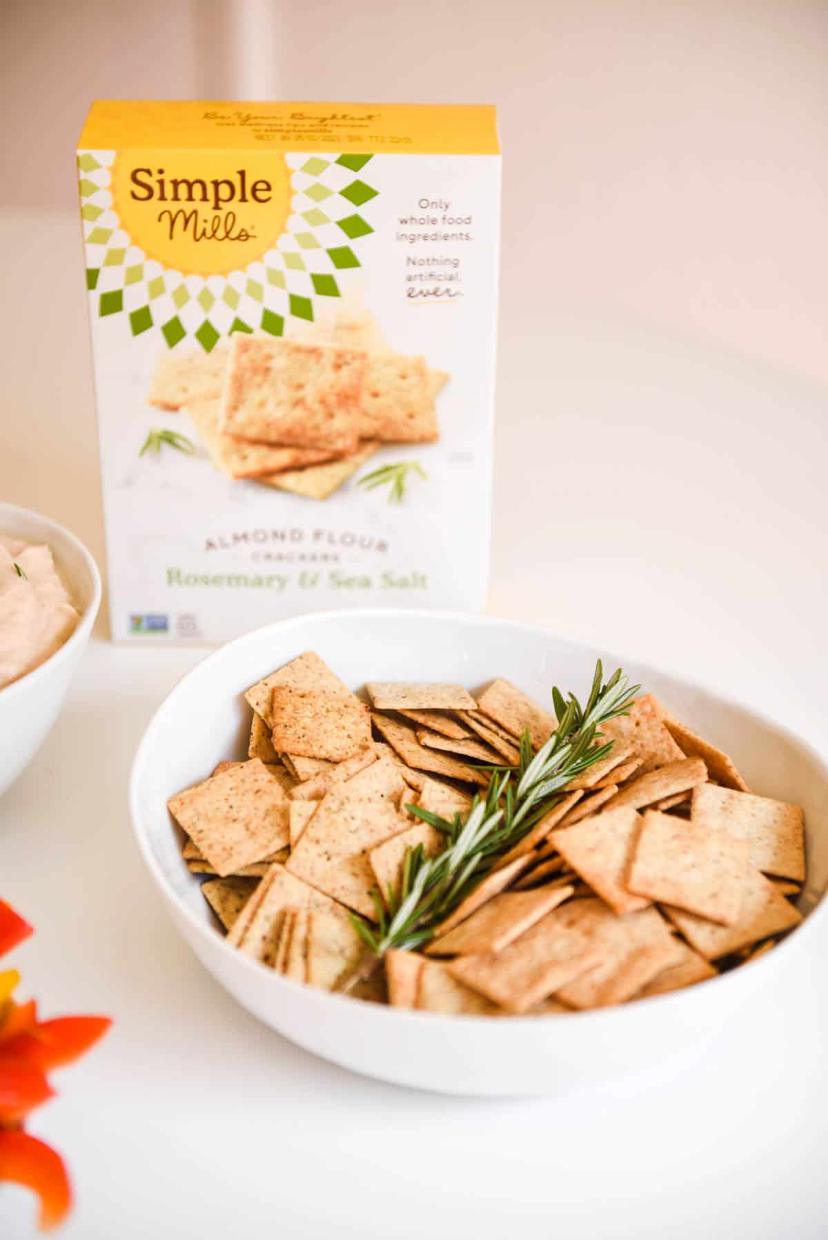 Close up of gluten free crackers in a bowl with the box behind it.