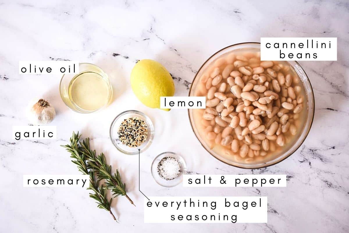 Labeled ingredients to make vegan white bean dip laying on a counter.