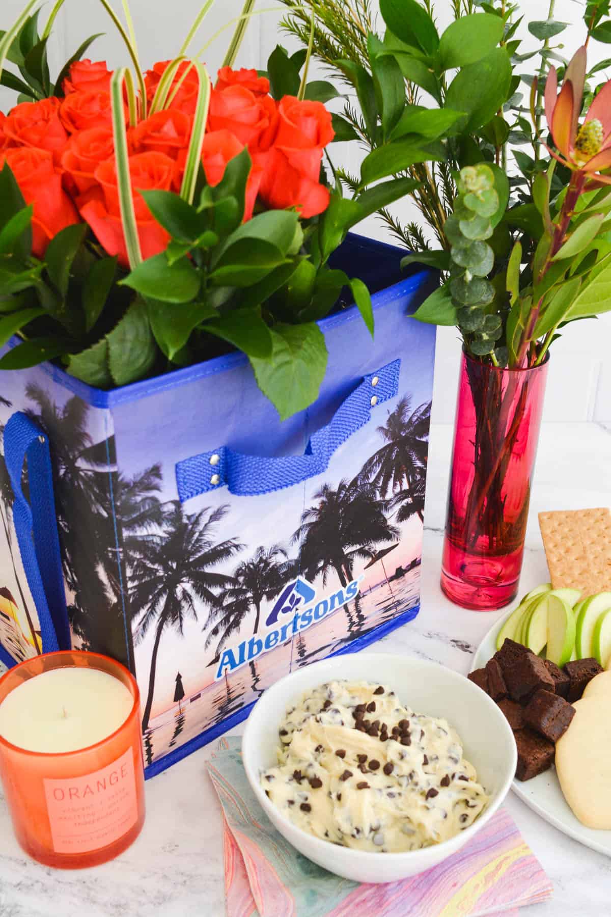 An Albertsons reusable bag next to Debi Lily candles and vases and a dessert dip.